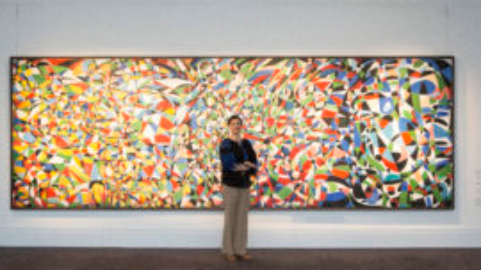 Image of Adila Laïdi-Hanieh standing in front of large abstract painting