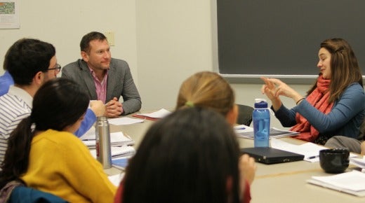 A classroom featuring a student talking while the instructor and other students listen