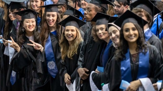 A graduation photo of six students wearing caps and gowns