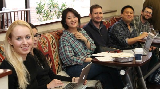 Students studying with their laptops open in the CCAS main lobby