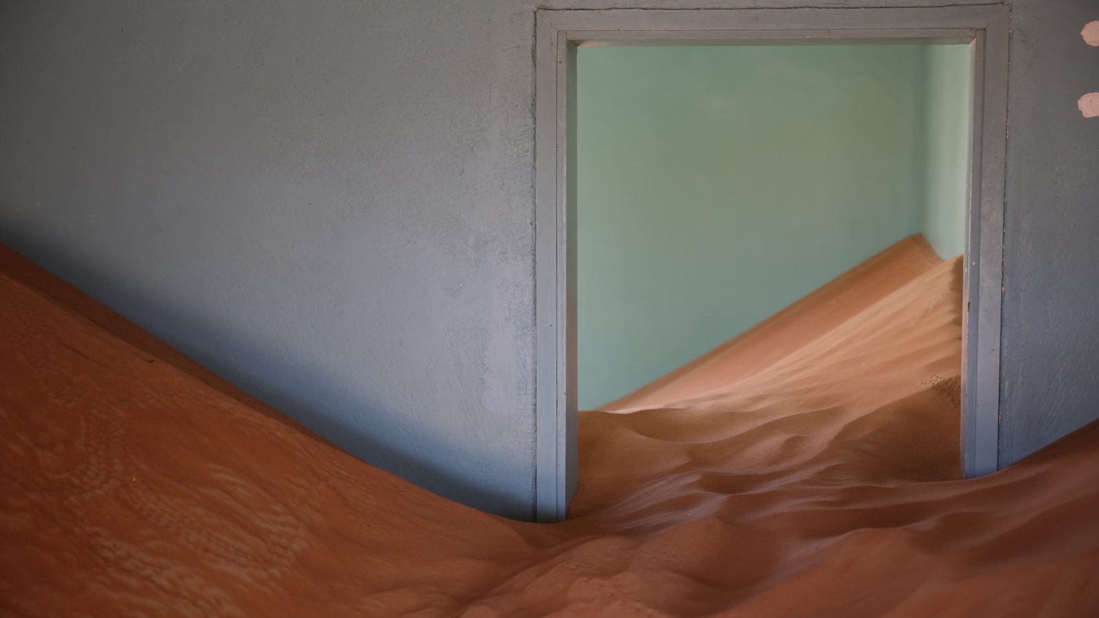 picture of sand that has overtaken the inside of an abandoned house