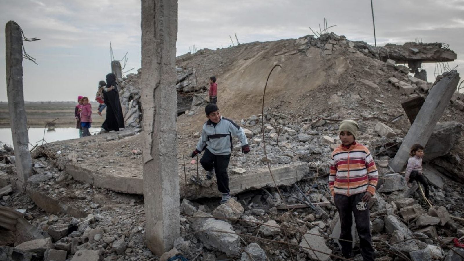 CHILDREN PLAY AMID RUBBLE ON FEBRUARY 16, 2019 IN HAJIN, SYRIA. AERIAL BOMBARDMENTS HAVE POLLUTED GROUNDWATER AND CREATED SEVERE AIR POLLUTION. EXPLOSIVE WEAPONS LEAVE A HEAVY TOXIC FOOTPRINT BEHIND FOR CIVILIANS WHO HAVE ALREADY ENDURED YEARS OF BOMBING. SOURCE: CHRIS MCGRATH/GETTY IMAGES