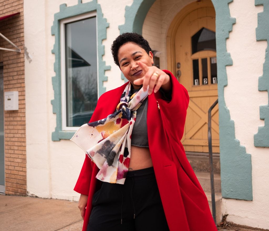 Anela Malik wearing a red coat 