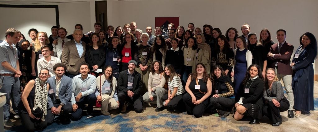 Alums, students, faculty, and former and current staff pose for a group picture