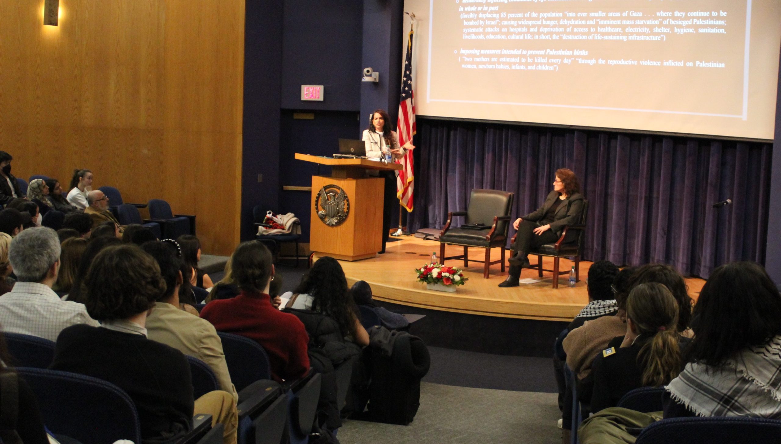 Nour Erakat speaking at a podium on stage